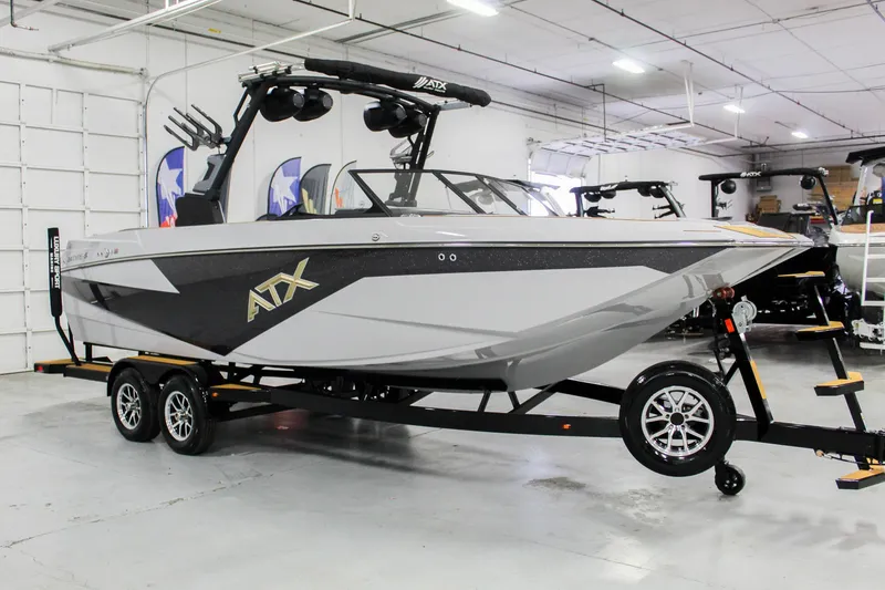 Slide: The Image of 2025 ATX Surf Boats 24 Type-S in showroom, sleek design, dual-axle trailer. - 6
