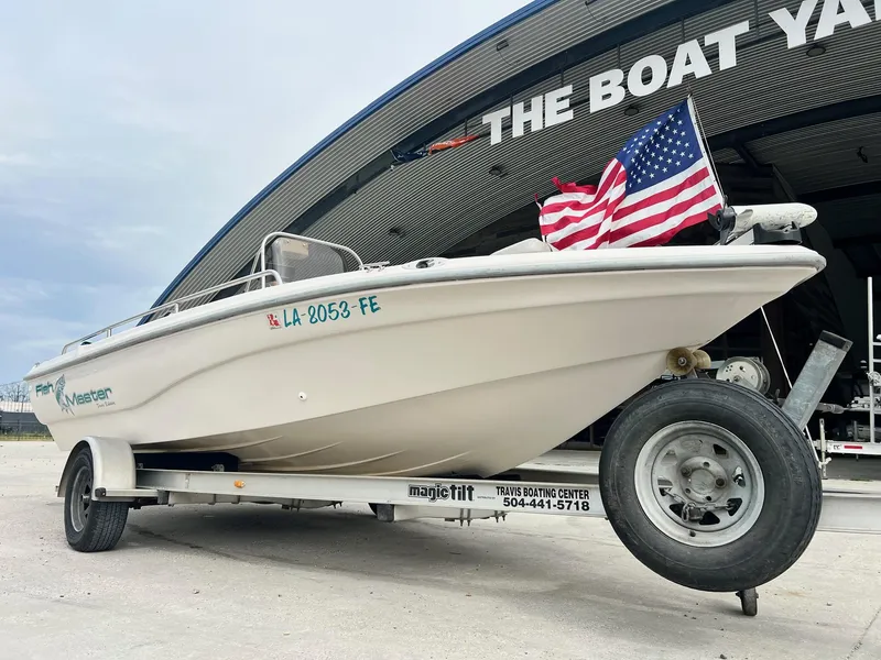 Slide: The Image of Fishmaster 1960 boat on trailer with American flag, parked at The Boat Yard. - 2