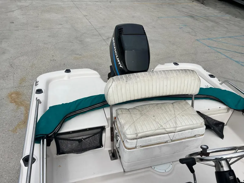 Slide: The Image of Fishmaster 1960 boat interior with Mercury engine, white seating, and teal accents, 2002 model. - 5