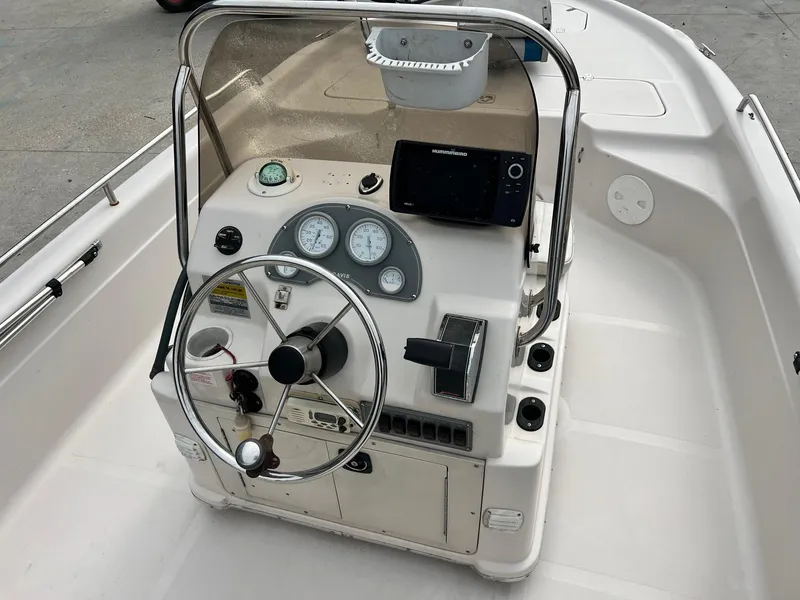 Slide: The Image of Center console of a 2002 Fishmaster 1960 boat with steering wheel and navigation equipment. - 8