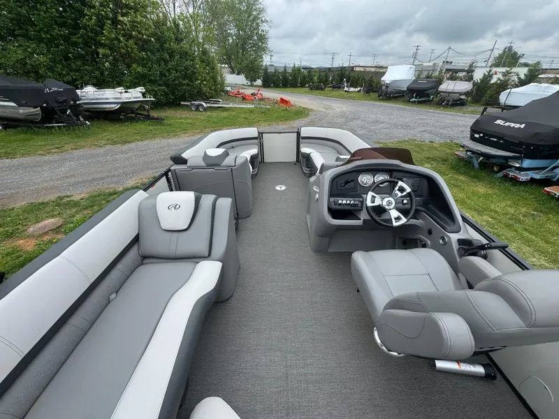 Slide: The Image of 2021 Avalon Catalina Rear J Lounger 25' pontoon boat interior with gray seating and steering console. - 14