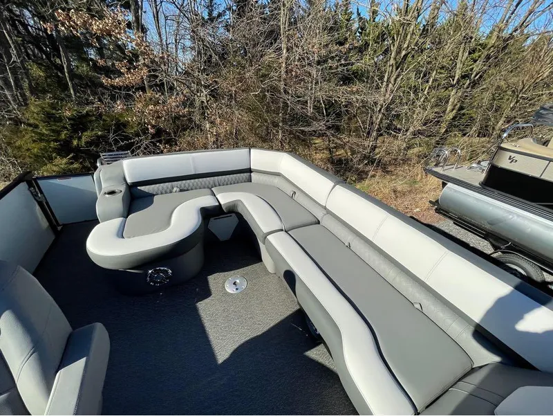Slide: The Image of 2021 Avalon Catalina Rear J Lounger 25' boat interior with gray seating and forest backdrop. - 21