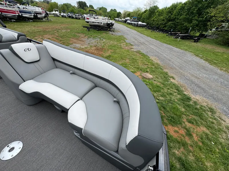 Slide: The Image of 2021 Avalon Catalina Rear J Lounger 25' boat with gray and white seating, parked outdoors. - 35