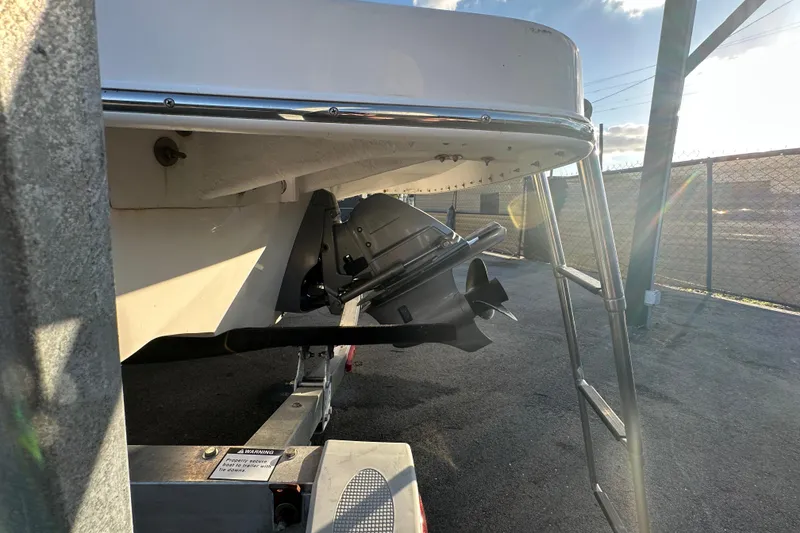 Slide: The Image of 2017 Regal 1900 Bowrider boat on trailer, showing propeller and ladder in sunlight. - 10