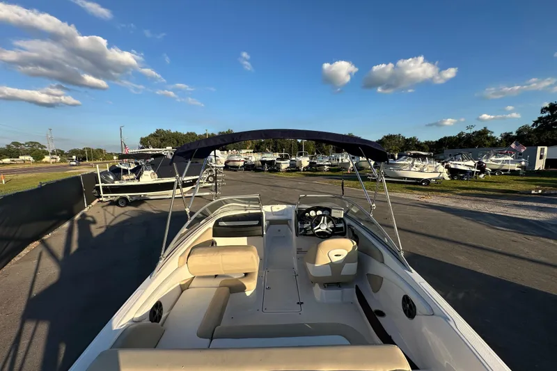 Slide: The Image of 2017 Regal 1900 Bowrider boat with canopy, parked in a marina under a clear blue sky. - 15