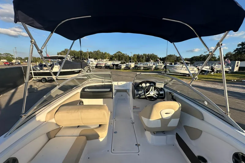 Slide: The Image of 2017 Regal 1900 Bowrider boat interior with canopy, parked in marina. - 18