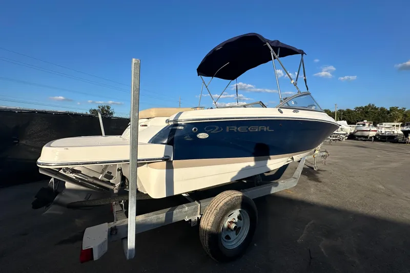 Slide: The Image of 2017 Regal 1900 Bowrider boat on trailer under clear blue sky. - 2