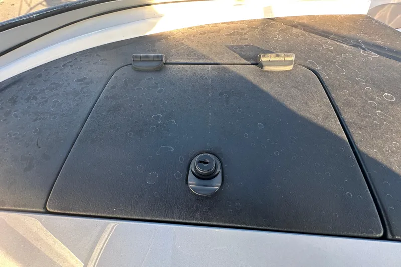 Slide: The Image of 2017 Regal 1900 Bowrider boat hatch with latch, showing surface wear. - 24