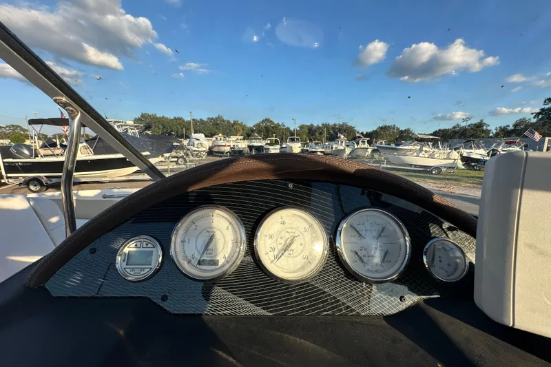 Slide: The Image of Dashboard view of a 2017 Regal 1900 Bowrider boat with gauges and marina background. - 29