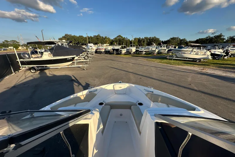 Slide: The Image of 2017 Regal 1900 Bowrider in a boatyard with multiple boats under a clear sky. - 35