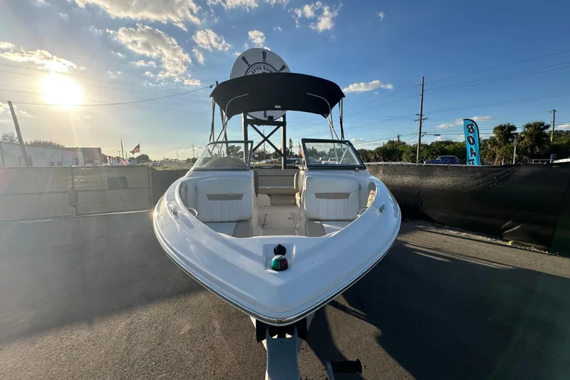 Slide: The Image of 2017 Regal 1900 Bowrider boat with canopy, parked under a sunny sky. - 4
