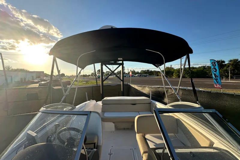 Slide: The Image of 2017 Regal 1900 Bowrider boat with canopy, parked under a sunny sky. - 50