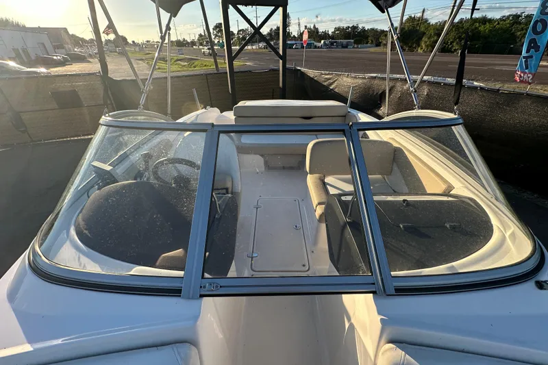 Slide: The Image of 2017 Regal 1900 Bowrider boat interior with seating and steering wheel, parked outdoors. - 52