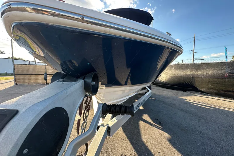 Slide: The Image of 2017 Regal 1900 Bowrider boat on trailer, parked outdoors under clear sky. - 6
