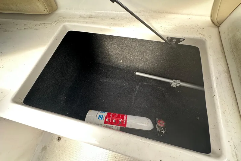 Slide: The Image of 2017 Regal 1900 Bowrider storage compartment with fire extinguisher and hydraulic support. - 60