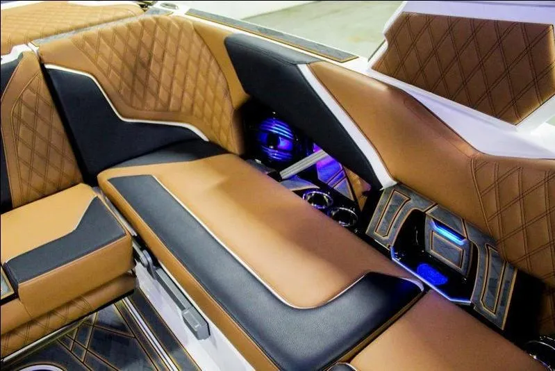 Slide: The Image of Luxurious interior of 2025 Tigé 22RZX boat with brown and black seating, blue LED lighting. - 20