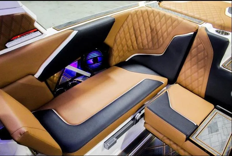 Slide: The Image of 2025 Tigé 22RZX interior with luxurious brown and black seating, featuring modern design elements. - 22