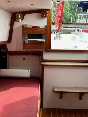 Slide: The Image of Interior of a 2000 Great Harbour 26 ft. boat with red seating and wooden accents. - 10