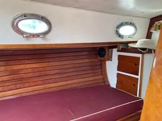 Slide: The Image of Interior cabin of a 2000 Great Harbour 26 ft. boat with wooden paneling and portholes. - 11