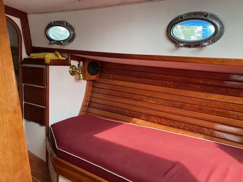 Slide: The Image of Interior of 2000 Great Harbour 26 ft. boat with wooden paneling and red cushioned seating. - 12