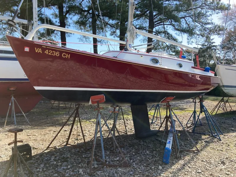 Slide: The Image of Red Great Harbour 26 ft. sailboat from 2000 on stands, surrounded by trees. - 17