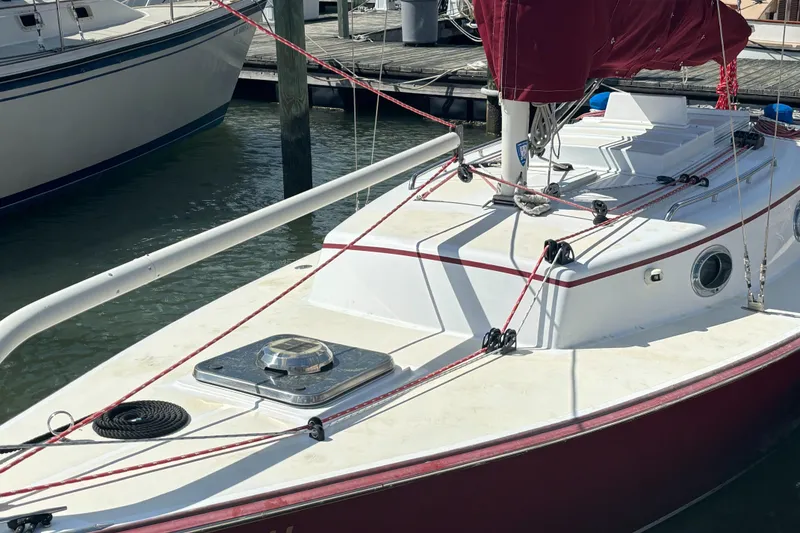 Slide: The Image of 2000 Great Harbour 26 ft. sailboat docked with red sail and rigging. - 21