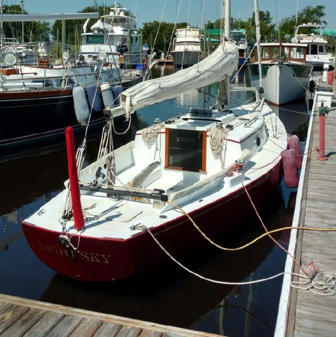 Slide: The Image of 2000 Great Harbour 26 ft. sailboat docked, red hull, white deck, marina setting. - 3