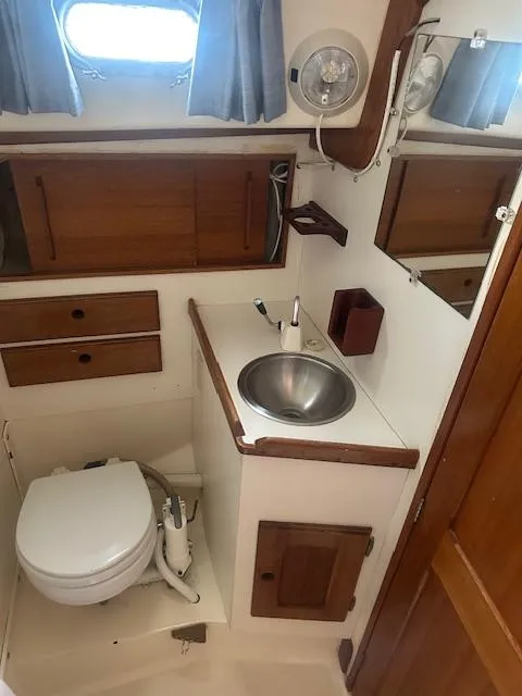 Slide: The Image of 1979 Bristol 299 boat bathroom with sink, toilet, and wooden cabinets. - 10