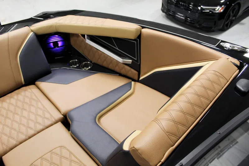 Slide: The Image of 2025 Tigé 22RZX boat interior with luxurious tan and black seating, quilted design, and cup holders. - 11