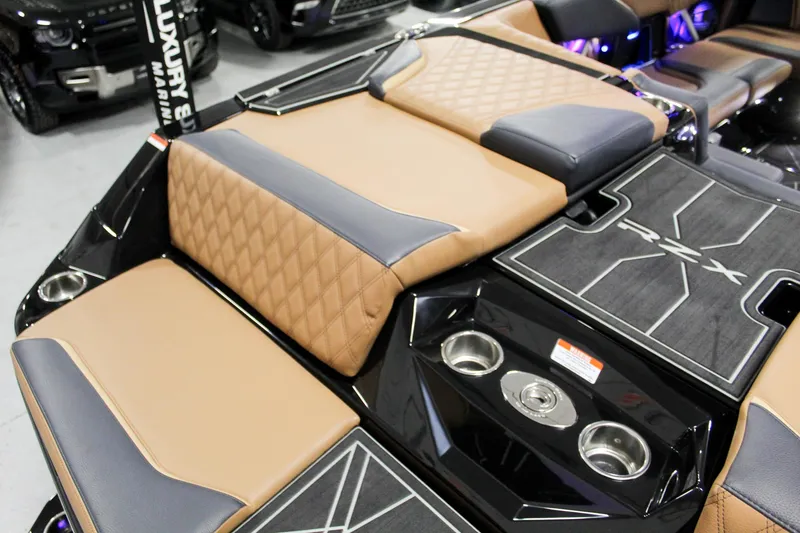 Slide: The Image of 2025 Tigé 22RZX boat interior with tan and black upholstery, featuring cup holders and luxury design. - 22