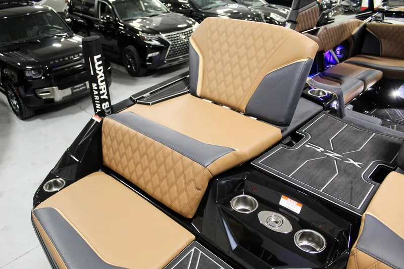 Slide: The Image of 2025 Tigé 22RZX boat interior with luxury seating and cup holders in showroom. - 25