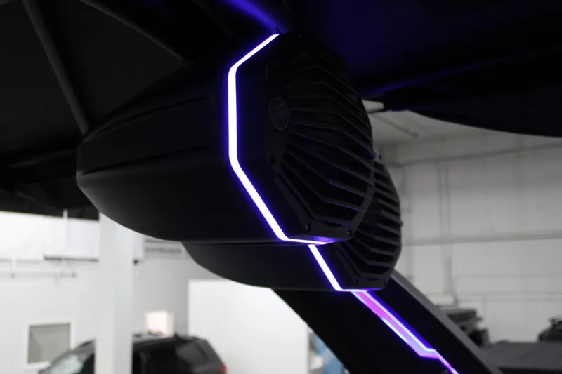 Slide: The Image of 2025 Tigé 22RZX boat speaker with purple LED lighting in a showroom. - 29