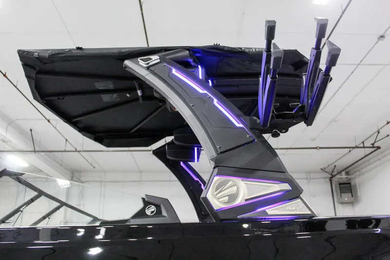 Slide: The Image of 2025 Tigé 22RZX boat with illuminated wakeboard tower in a showroom. - 30