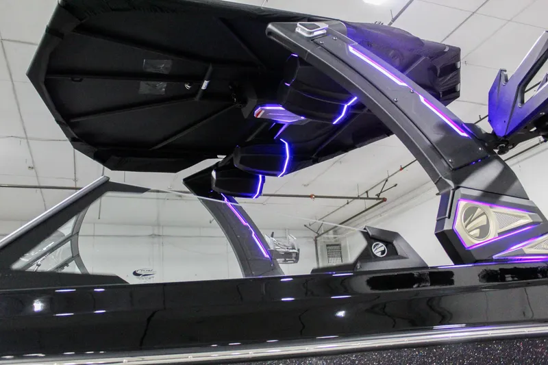 Slide: The Image of 2025 Tigé 22RZX boat with illuminated tower and sleek black design in showroom. - 31