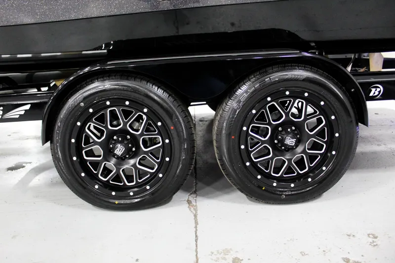 Slide: The Image of 2025 Tigé 22RZX trailer wheels, black alloy rims, dual axle design. - 32