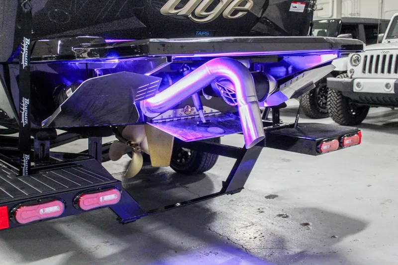 Slide: The Image of 2025 Tigé 22RZX boat with illuminated exhaust and trailer in a garage setting. - 33