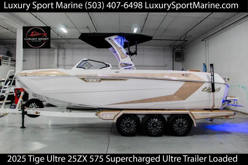 Slide: The Image of 2025 Tigé Ultré 25ZX boat on trailer in showroom, Luxury Sport Marine. - 0
