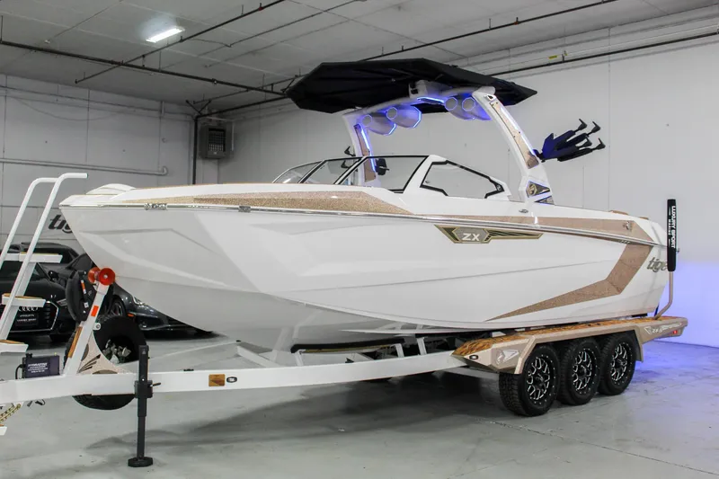 Slide: The Image of 2025 Tigé Ultré 25ZX boat on trailer in indoor showroom. - 1
