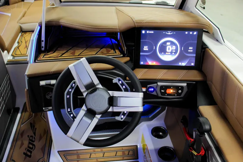 Slide: The Image of 2025 Tigé Ultré 25ZX boat dashboard with modern steering wheel and digital display. - 19