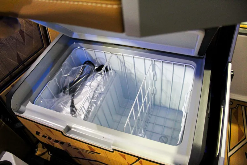 Slide: The Image of Open storage compartment in 2025 Tigé Ultré 25ZX boat, featuring organized interior space. - 23