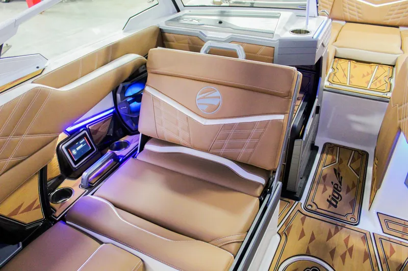 Slide: The Image of 2025 Tigé Ultré 25ZX boat interior with luxurious tan seating and modern dashboard. - 24