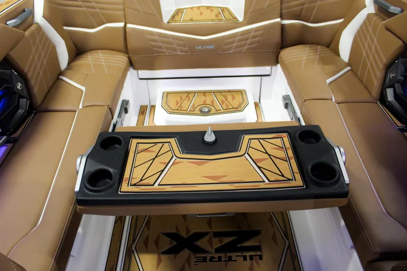 Slide: The Image of 2025 Tigé Ultré 25ZX boat interior with luxurious brown seating and stylish table design. - 27