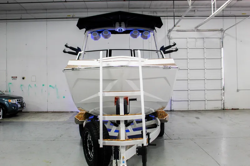 Slide: The Image of 2025 Tigé Ultré 25ZX boat in a garage, front view with trailer. - 3