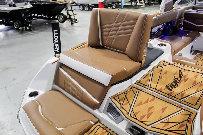 Slide: The Image of 2025 Tigé Ultré 25ZX boat interior with luxury brown seating and geometric flooring. - 34