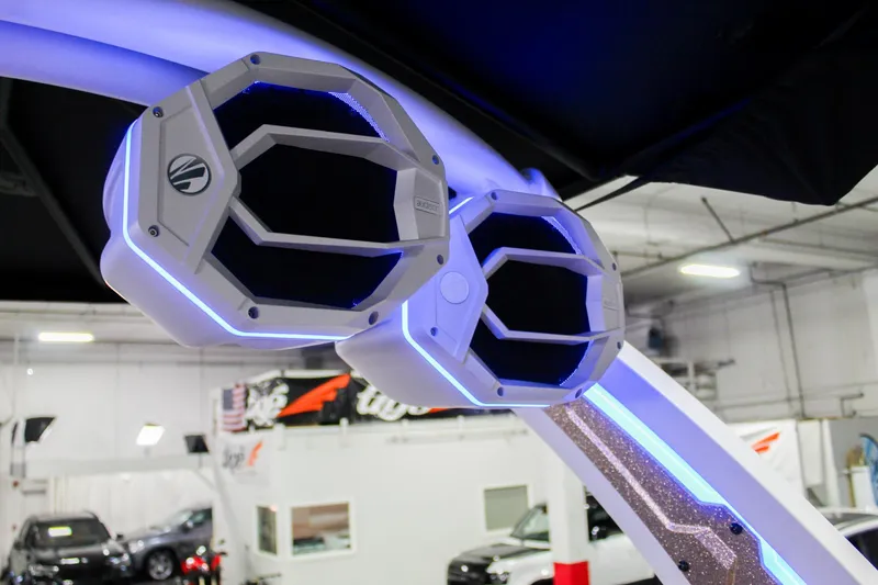 Slide: The Image of 2025 Tigé Ultré 25ZX boat speakers with blue LED lighting in a showroom. - 40
