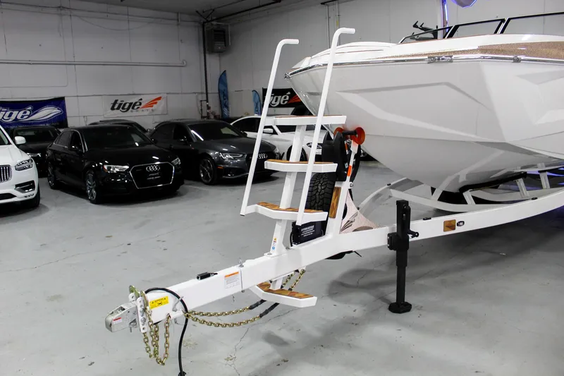 Slide: The Image of 2025 Tigé Ultré 25ZX boat on trailer in showroom with luxury cars. - 41