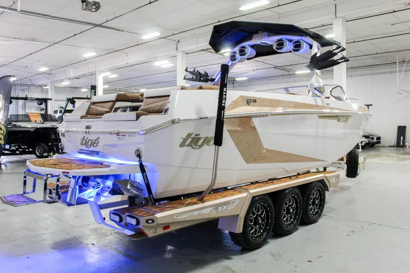 Slide: The Image of 2025 Tigé Ultré 25ZX boat on trailer, illuminated in showroom with modern design features. - 5