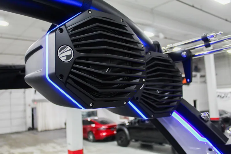 Slide: The Image of 2025 Tigé Z3 boat speakers with blue LED lighting in a showroom. - 29