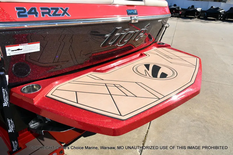 Slide: The Image of 2022 Tigé 24RZX boat with red exterior and custom swim platform. - 10