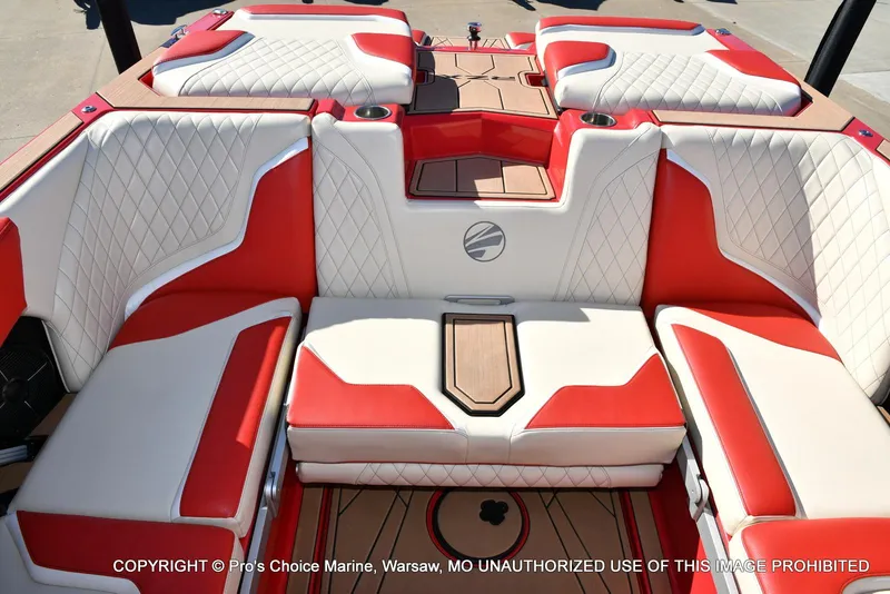 Slide: The Image of 2022 Tigé 24RZX boat interior with red and white seating, diamond stitching, and cup holders. - 17